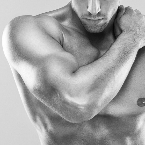 muscular man with his arm on his shoulder